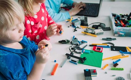 Kids building robot and programming it on computer