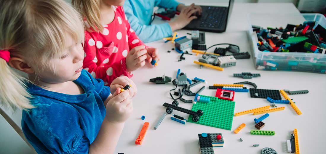 Kids building robot and programming it on computer