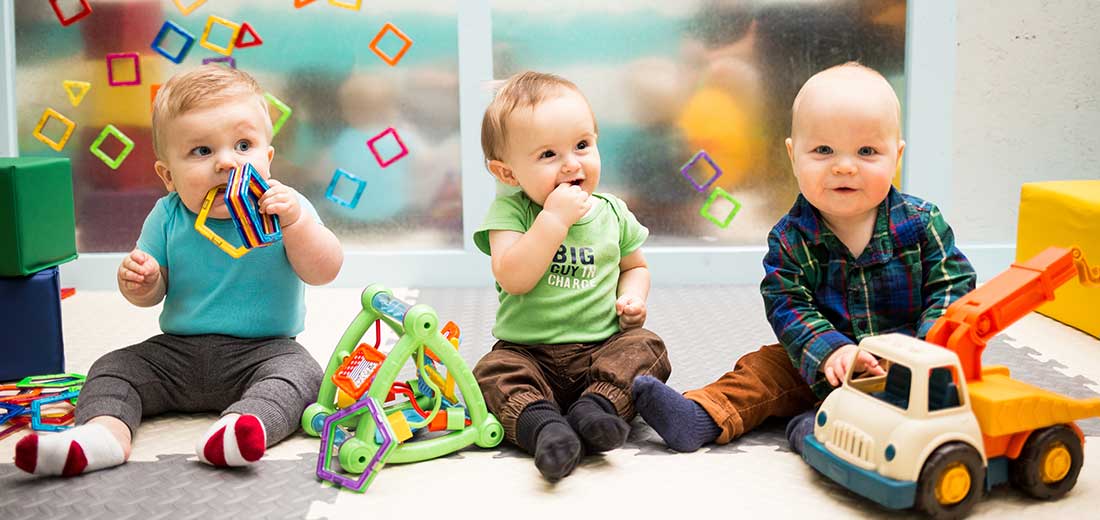 Three Babies Sitting Up and Playing with Toys